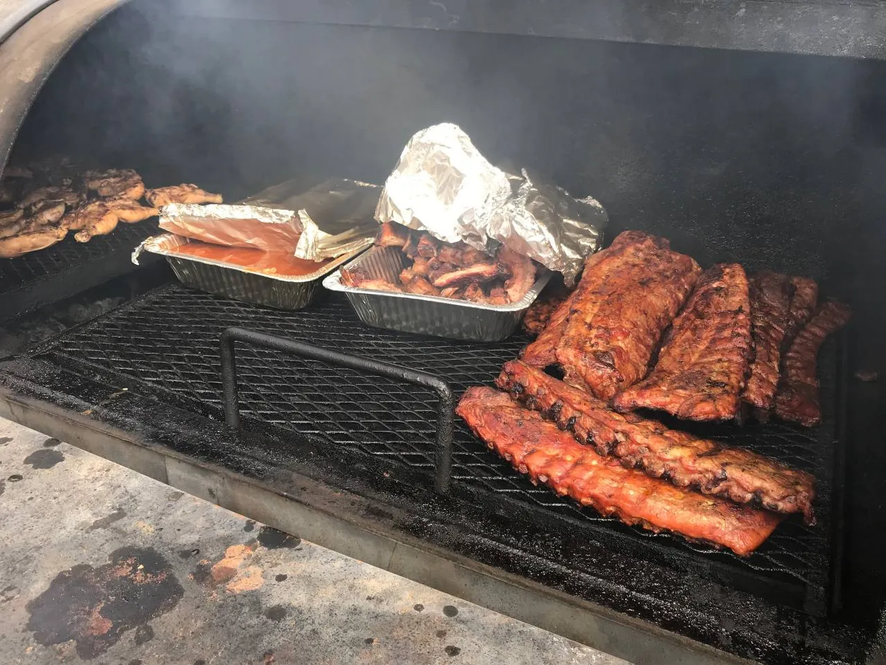 Jerry Willis tending the smoker, surrounded by rising hardwood smoke