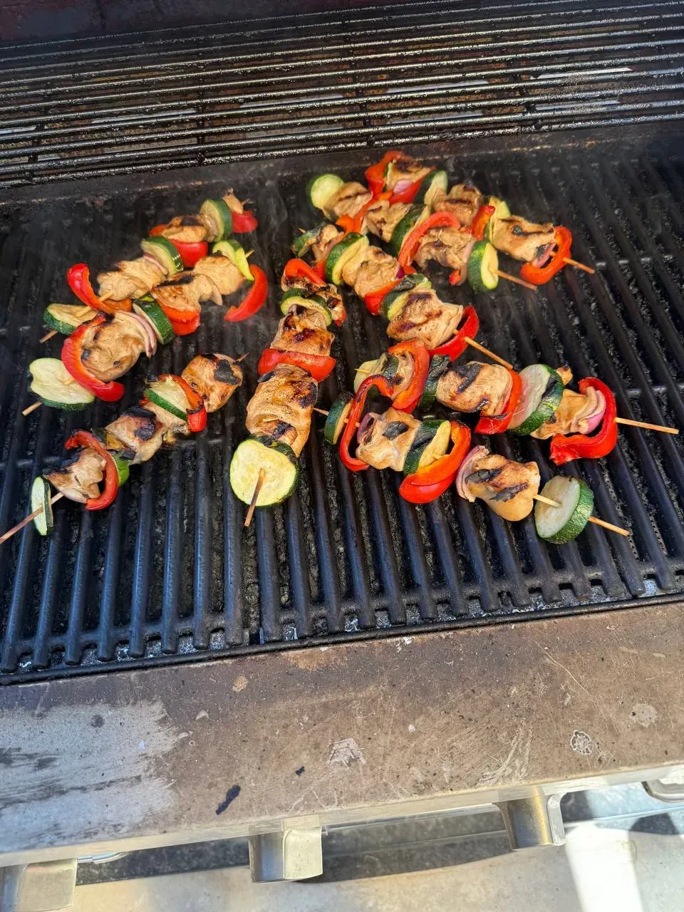 Skewers of marinated chicken and vegetables grilling at a Pitmaster’s Secret Phoenix catering event