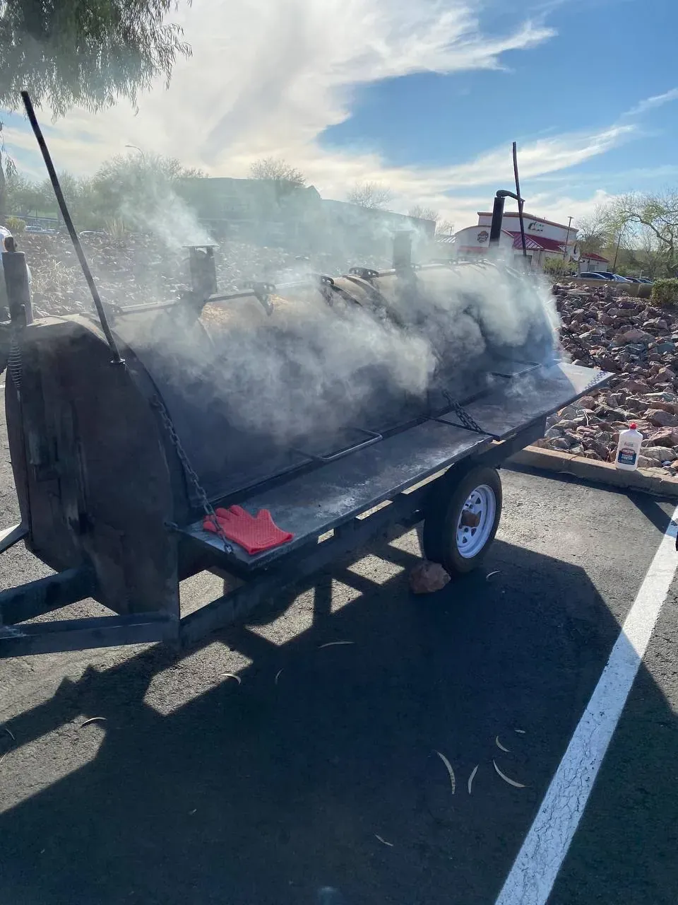 The Pitmaster’s Secret trailer smoker billowing hardwood smoke under a Phoenix sky