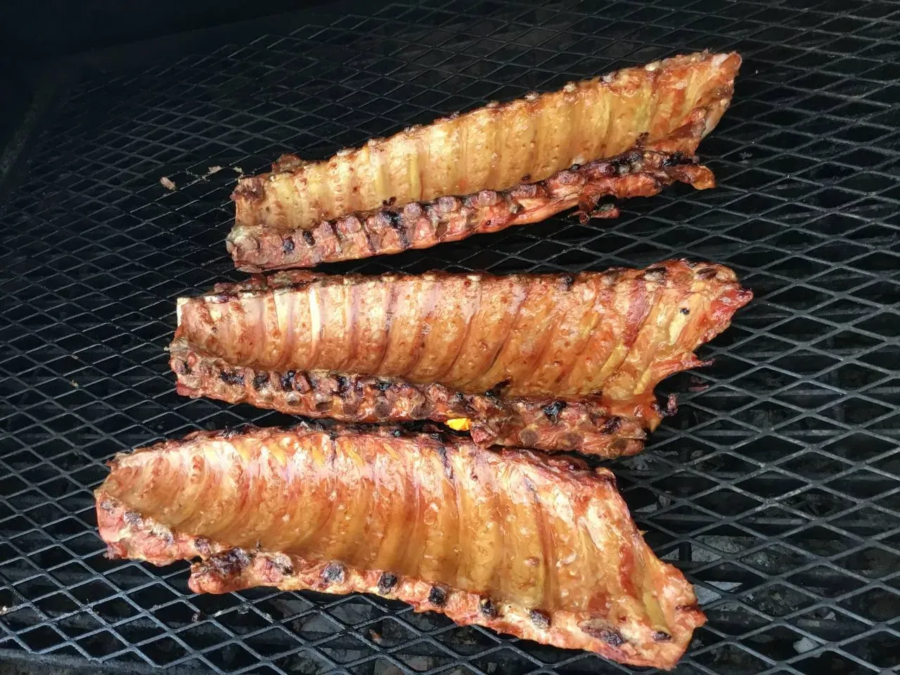Bacon-wrapped specialty cuts on the smoker grate at a Pitmaster’s Secret Arizona event
