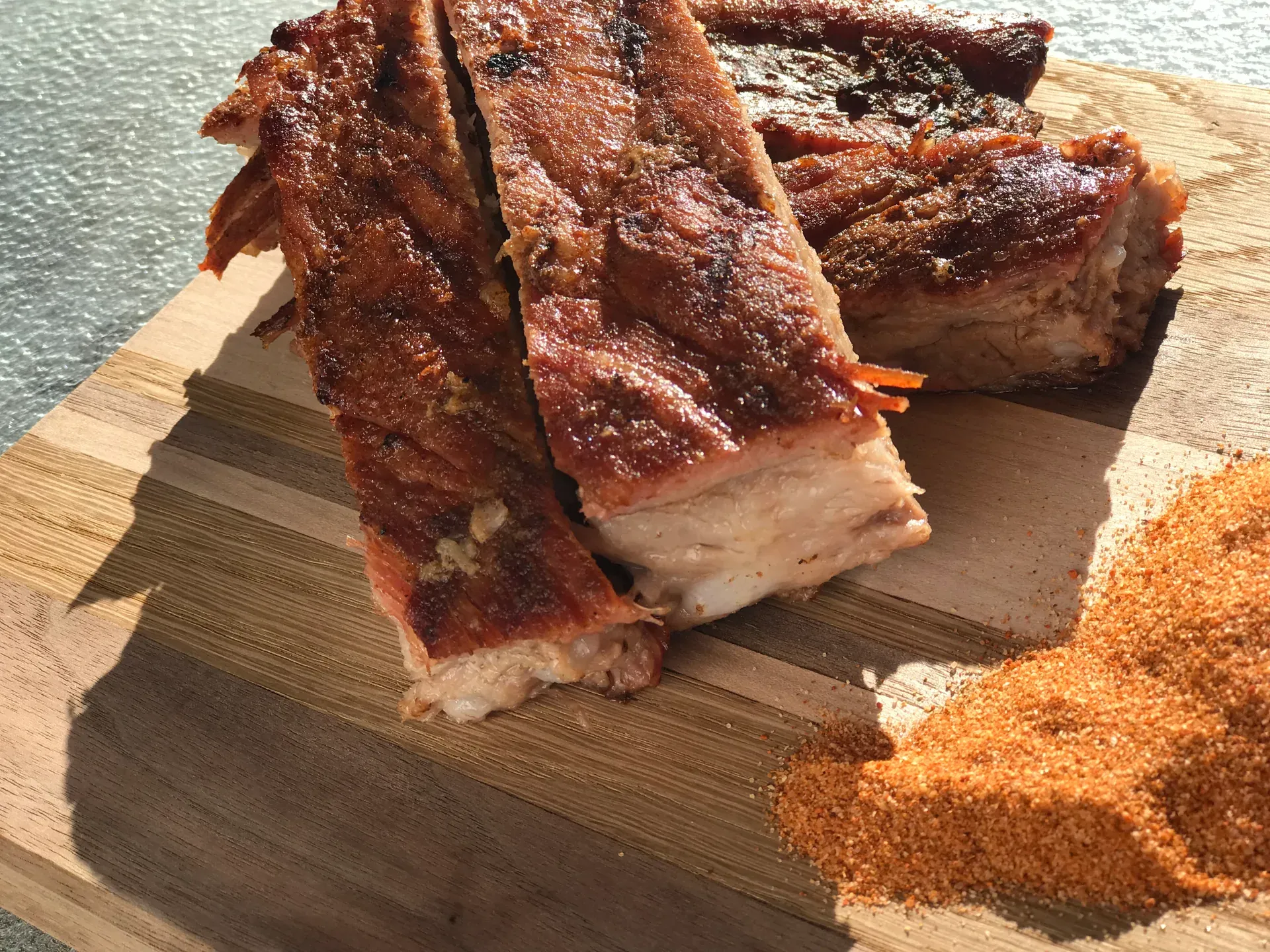 Thick-cut smoked beef ribs from The Pitmaster’s Secret on a cutting board next to a pile of champion dry rub